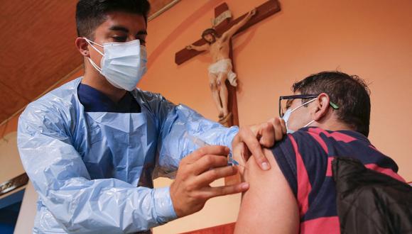 Un trabajador de salud administra una dosis de la vacuna Pfizer BioNTech contra el coronavirus COVID-19 a un hombre en la iglesia Medalla Milagrosa en Valparaíso, Chile, el 6 de abril de 2021. (Foto de JAVIER TORRES / AFP).