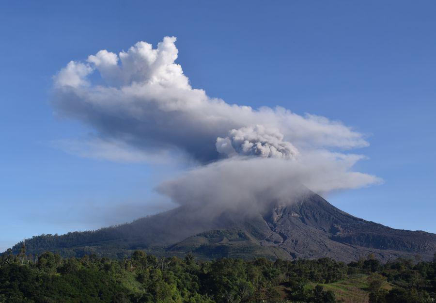 El volcán Sinabung arroja humo denso al aire en Karo, en el norte de Sumatra (Indonesia, el 23 de agosto de 2020 (Foto de ANTO SEMBIRING / AFP).