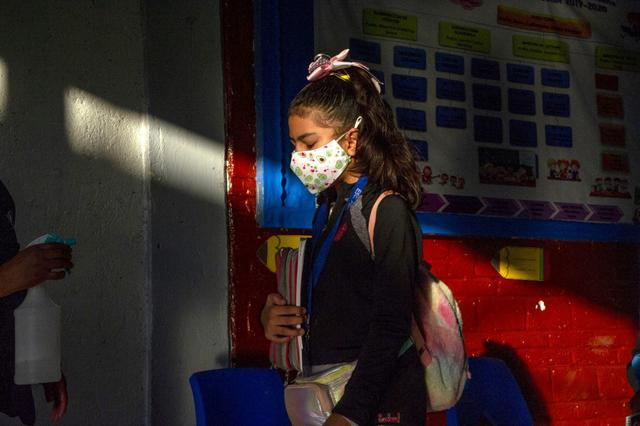 Una niña es desinfectada cuando ingresa a una escuela durante la reanudación de las clases presenciales en la Ciudad de México. (Foto de CLAUDIO CRUZ / AFP)