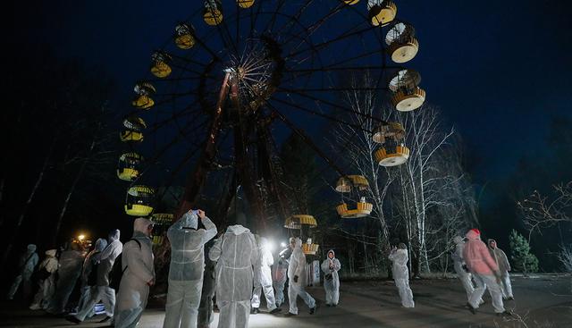 Visitantes caminan por un parque de diversiones en la ciudad abandonada de Prypyat, cerca de la central nuclear de Chernóbil (Ucrania). (EFE)