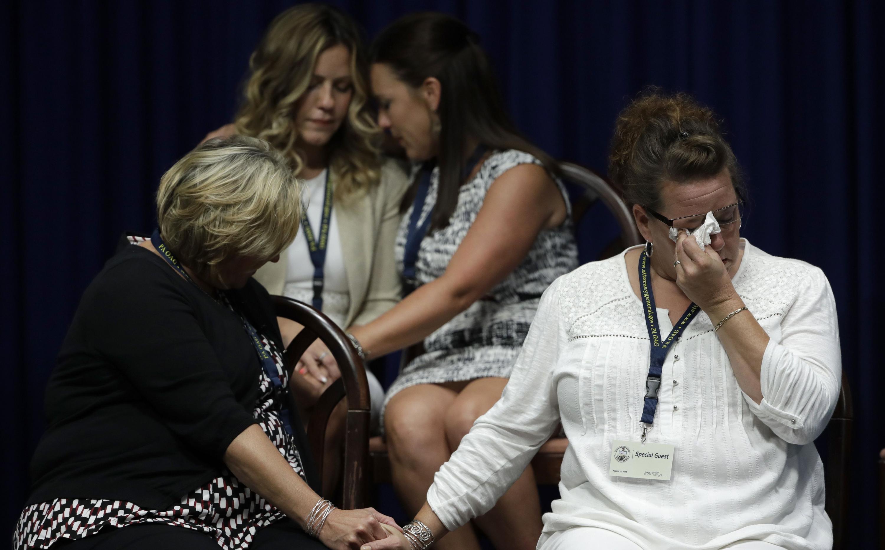 Víctimas de abusos sexuales lloran durante la presentación del fiscal general de Pensilvania, Josh Shapiro, quien reveló un informe sobre abusos sexuales en la iglesia. (AP).