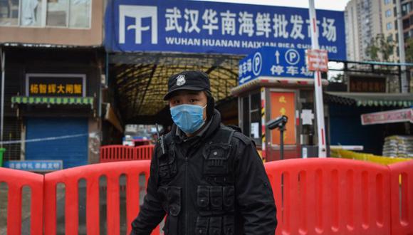 Un oficial de policía hace guardia fuera del mercado mayorista de mariscos de Huanan, donde se detectó el coronavirus en Wuhan. (Foto: Hector RETAMAL / AFP/ Archivo).