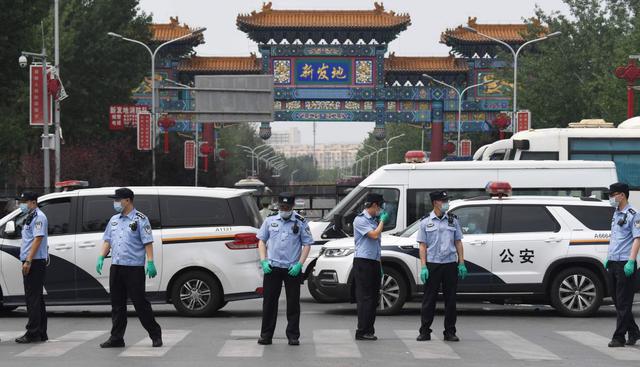 La policía china vigila este sábado la entrada al mercado cerrado de Xinfadi en Beijing. Nuevos casos de coronavirus obligaron al confinamiento de una zona en la capital de China.  (AFP / GREG BAKER).