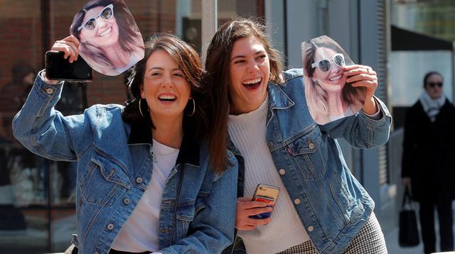 Dos personas con la imagen de la actriz Lori Loughlin en el exterior de la corte federal de Boston este miércoles 3 de abril. (Foto: AP)