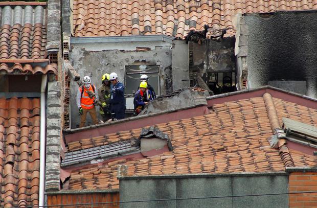 Los bomberos trabajan en el lugar donde se estrelló una avioneta que dejó ocho muertos en el barrio de Belén Rosales en Medellín, Colombia, el 21 de noviembre de 2022. (FREDDY BUILES / AFP).
