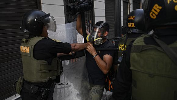 Un policía empuja a un periodista durante una protesta contra el gobierno de la presidenta peruana Dina Boluarte en Lima el 17 de enero de 2023. (Foto de ERNESTO BENAVIDES/AFP).
