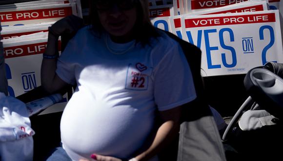 Una mujer embarazada se sienta frente a carteles en Frankfort, Kentucky, el 1 de octubre de 2022. (Foto referencial de Stefani Reynolds / AFP)