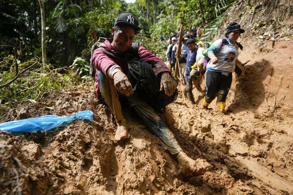 Migrants, mostly Venezuelans, cross the Darién Gap from Colombia to Panama in hopes of reaching the United States, Saturday, Oct. 15, 2022. (AP Photo/Fernando Vergara)