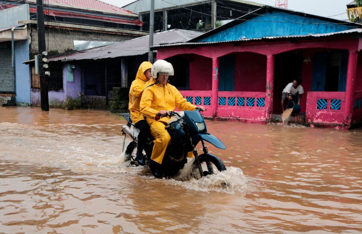 Residents ride motorcycles on a flooded street in the aftermath of Hurricane Julia in the city of Bluefields, on Nicaragua's Caribbean coast.  (OSWALDO RIVAS / AFP).