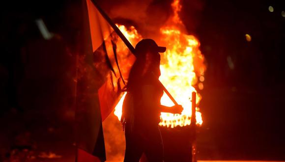 Fotografía del 3 de mayo de 2021 que muestra a un grupo de manifestantes que incendian llantas mientras bloquean vías durante las protestas en Cali, Colombia. (EFE/ Ernesto Guzmán Jr).