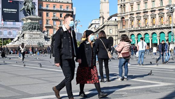 Una pareja lleva una máscara protectora mientras caminan por la Piazza del Duomo, en el centro de Milán, donde se tomaban medidas de seguridad en el norte de Italia contra el COVID-19. (Foto: AFP)