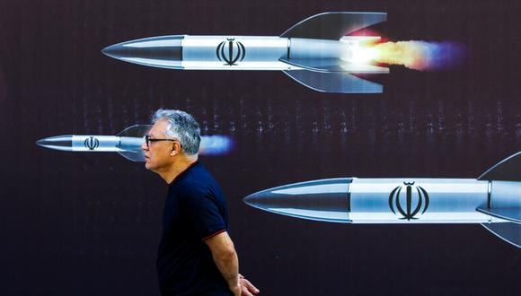 Un hombre pasa junto a una pancarta que representa misiles a lo largo de una calle de Teherán el 19 de abril de 2024. (Foto de AFP)