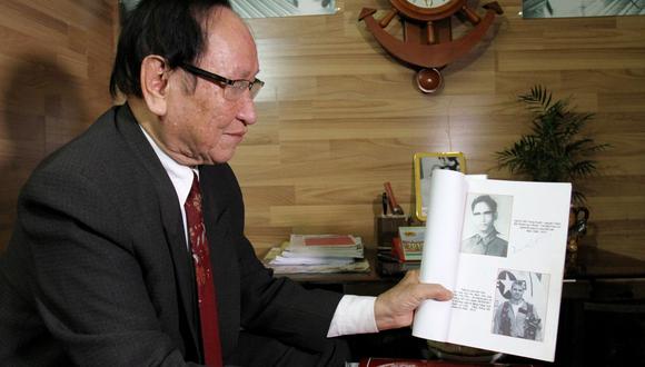 Tran Trong Duyet, 85 años, muestra una foto de John McCain. En su libro de memorias, "Faith of my Fathers", relató cómo lo habían mantenido durante horas colgado de una cuerda. (AFP).