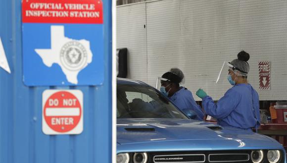 Unas personas administran pruebas de COVID-19 en un centro de inspección, en San Antonio, Texas, el martes 7 de julio de 2020. (AP Foto/Eric Gay).