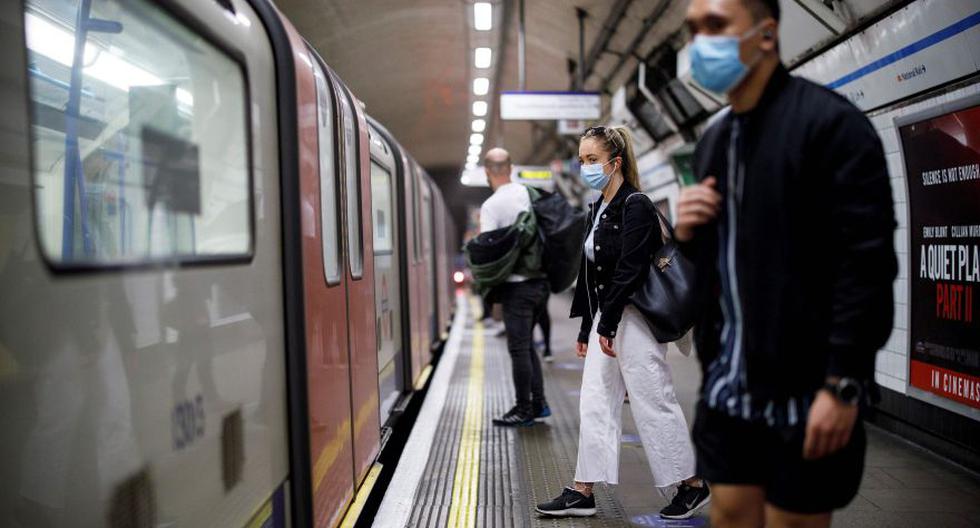Un grupo de pasajeros utilizan mascarillas faciales mientras viajan en los vagones del subterráneo TfL Victoria Line, en dirección al centro de Londres. (AFP / Tolga AKMEN)