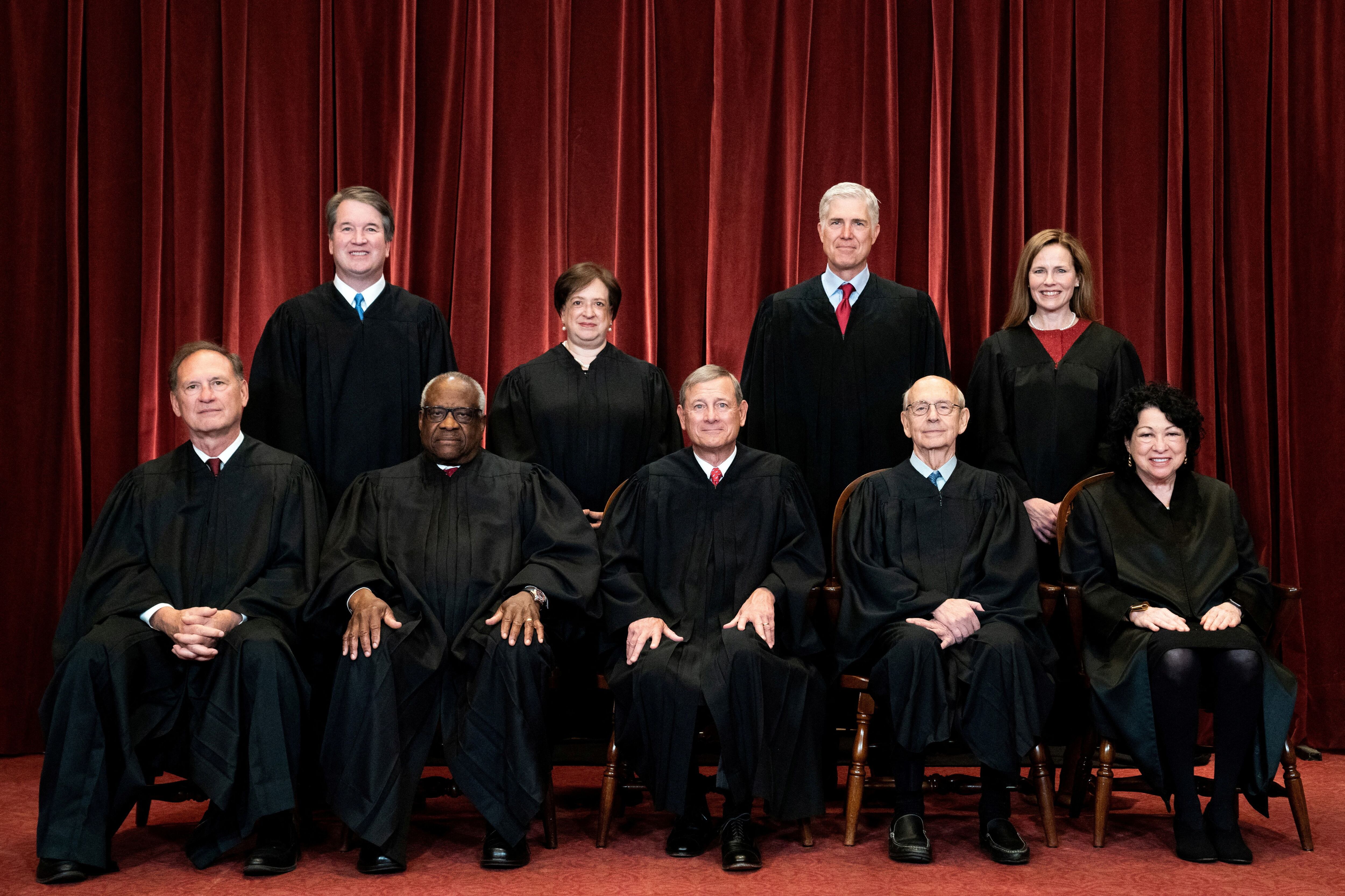The nine members of the United States Supreme Court: Standing are Brett Kavanaugh, Elena Kagan, Neil Gorsuch and Amy Coney Barrett.  Seated are Samuel Alito, Clarence Thomas, John Roberts, Stephen Breyer and Sonia Sotomayor.  REUTERS/File Photo