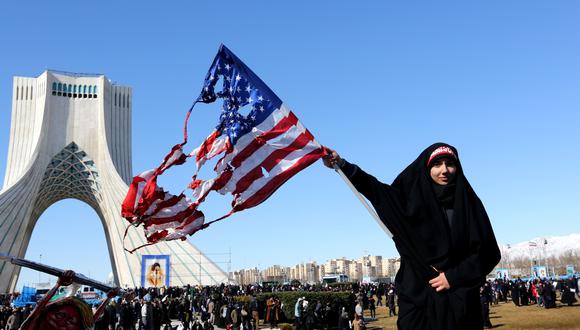 Una iraní ondea una bandera estadounidense quemada durante las conmemoraciones de los 41 años de la Revolución Islámica el 11 de febrero del 2020. (Foto por ATTA KENARE / AFP).