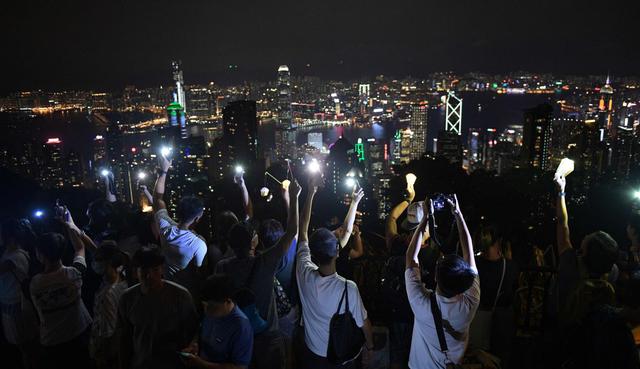 Miles de manifestantes prodemocracia en Hong Kong iluminaron el viernes con antorchas, linternas o sus celulares dos colinas del enclave, aprovechando la apertura de unas festividades tradicionales.&nbsp;(Foto: AFP)