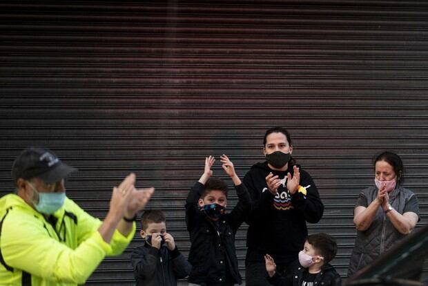 Una familia aplaude frente al Hospital Mount Sinai en Queens para mostrar su gratitud al personal médico y los trabajadores esenciales que trabajan en la primera línea para frenar la pandemia (Foto: Johannes Eisele / AFP)