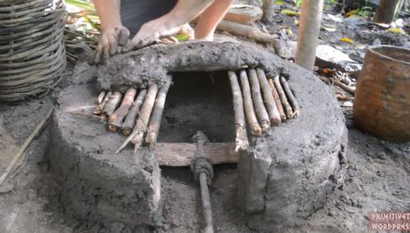 Construcción de un horno primitivo hecho a base de barro y ramas. (Foto: captura de YouTube)