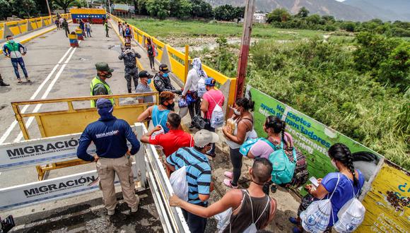 En esta foto de archivo tomada el 21 de agosto de 2020, venezolanos que regresan a casa hacen fila para que funcionarios colombianos de migración revisen sus documentos en el Puente Internacional Simón Bolívar, en Cúcuta, Colombia. (Foto: Schneyder MENDOZA / AFP)