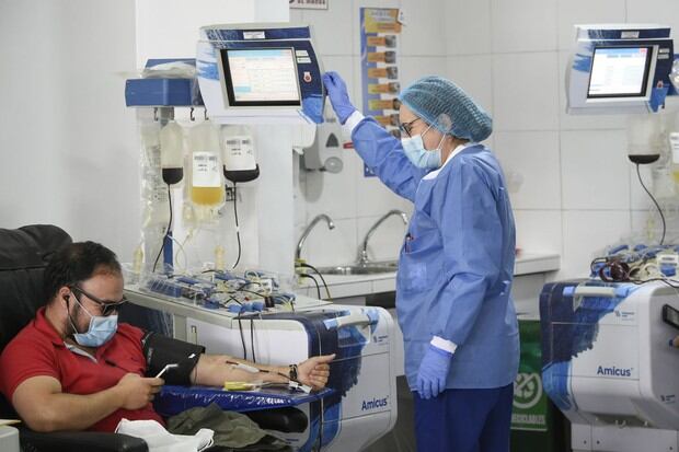 Un hombre usa una máscara facial mientras dona sangre en el banco de sangre de la Cruz Roja en Bogotá  (Foto: Juan Barreto / AFP)