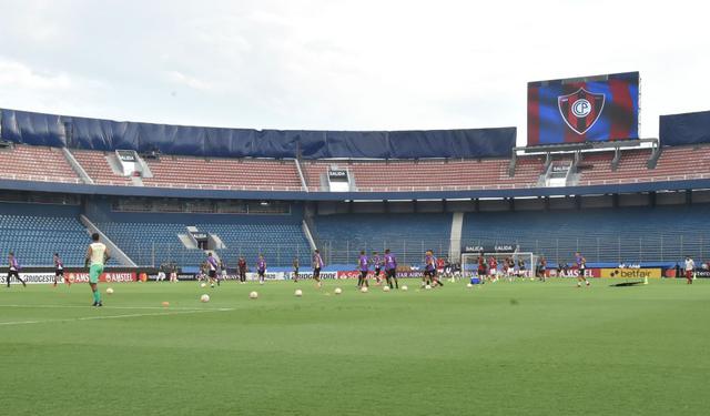 Player of Paraguay's Cerro Porteno (red) and Peru's Universitarios practice at General Pablo Rojas Stadium, home of Cerro Porteno, in Asuncion, on February 12, 2020, before their Copa Libertadores match. Cerro Porteno will play with an empty stadium, a sanction imposed by the Conmebol, for fans having used flares and fireworks in a match played last year against Argentina's River Plate..  / AFP / NORBERTO DUARTE