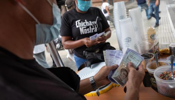 Vendedores cuentan billetes del antiguo cono monetario (Bolívar Soberano), el 22 de octubre de 2021, en Caracas, Venezuela. (EFE/ Rayner Peña R).