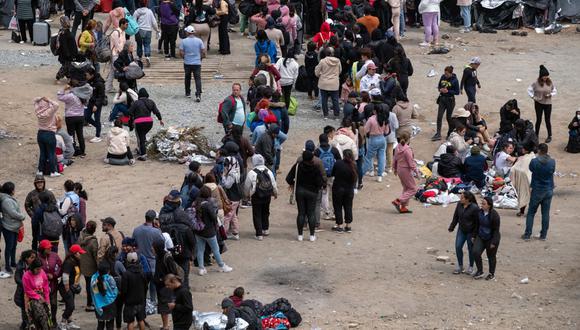 Los migrantes esperan ser procesados ​​por las autoridades estadounidenses en el lado estadounidense de la frontera entre Estados Unidos y México visto desde Tijuana, estado de Baja California, México, el 10 de mayo de 2023 (Foto: GUILLERMO ARIAS / AFP)
