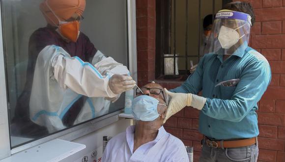 Trabajadores sanitarios recogen una muestra de hisopado nasal de un hombre para realizar una prueba del coronavirus COVID-19 en un hospital de la India. (Foto de NARINDER NANU / AFP).
