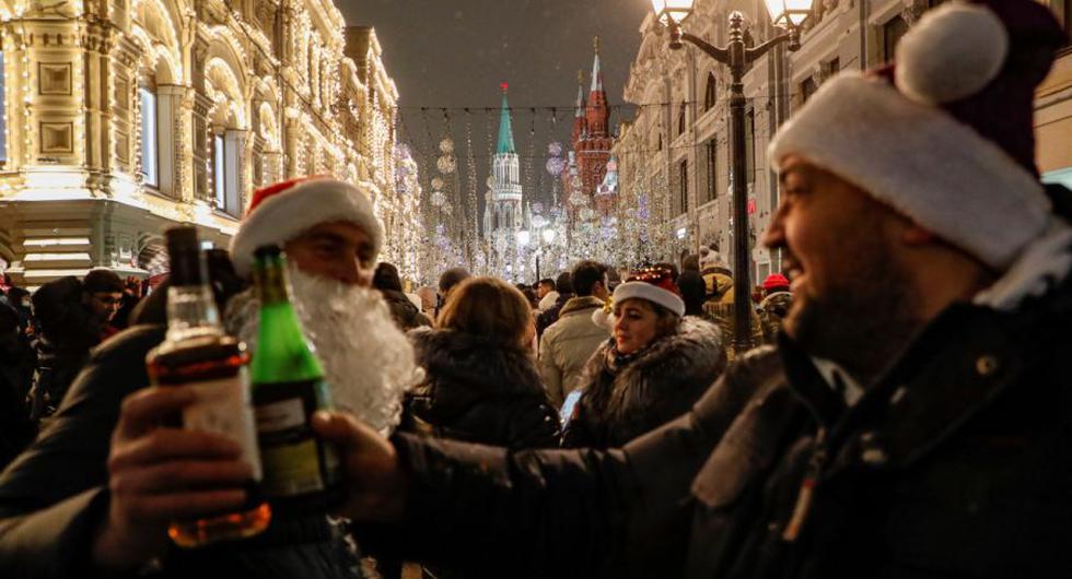 La gente se reúne cerca de la Plaza Roja en la víspera de Año Nuevo en Moscú, Rusia. (EFE / EPA / MAXIM SHIPENKOV).