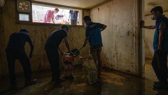 Trabajadores limpian un sótano inundado y cubierto de barro conocido como "banjiha" en el distrito de Gwanak de Seúl el 11 de agosto de 2022, después de las inundaciones causadas por lluvias récord.  (Foto: Anthony WALLACE / AFP)