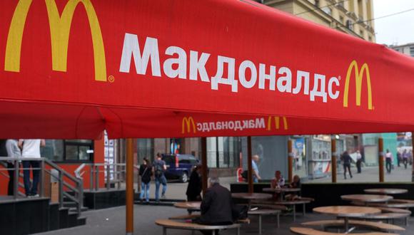 La gente se sienta en la terraza de un restaurante McDonald's cerrado en Moscú, capital de Rusia, el 21 de agosto de 2014. (ALEXANDER NEMENOV / AFP).