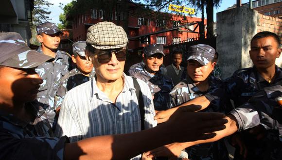 El asesino en serie francés Charles Sobhraj es guiado por policías de Nepal hacia un vehículo el 31 de mayo de 2011. (PRAKASH MATHEMA / AFP).