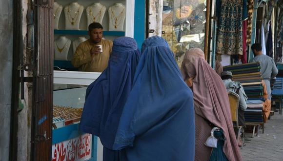 Mujeres afganas vestidas con burka caminan por un mercado en la plaza Chaharso en Kandahar, Afganistán, el 4 de agosto de 2022. (Javed TANVEER / AFP).