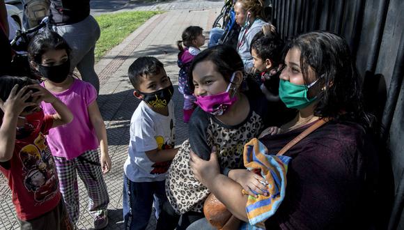Ciudadanos venezolanos varados a consecuencia de la pandemia de coronavirus permanecen fuera del consulado de Venezuela en Santiago. (Foto por MARTIN BERNETTI / AFP).
