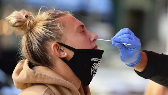 Un trabajador médico toma una muestra de un hisopo nasal de un estudiante para realizar una prueba de COVID-19 en la ciudad de Nueva York. (Foto: AFP / Angela Weiss)