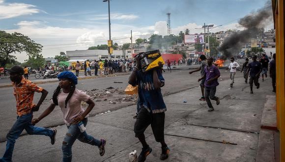 Un hombre carga un electrodoméstico tras un saqueo durante unas protestas hoy, en Puerto Príncipe, el 16 de septiembre de 2022. (Foto referencial de Johnson Sabin / EFE)