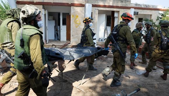 Soldados israelíes retiran el cuerpo de un compatriota muerto durante un ataque de Hamás en Kfar Aza, al sur de Israel, en la frontera con la Franja de Gaza, el 10 de octubre de 2023. (Foto de JACK GUEZ / AFP).