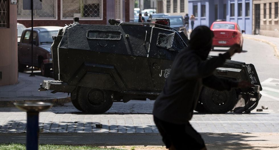 Manifestantes se enfrentan con la policía este lunes en Santiago. (EFE/Alberto Valdes).