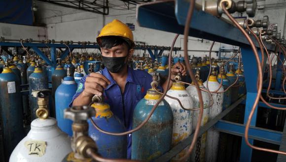 Un trabajador rellena cilindros de oxígeno en una instalación de distribución en Semarang, Java Central, Indonesia. (Foto: Dimas Ardian / Bloomberg).