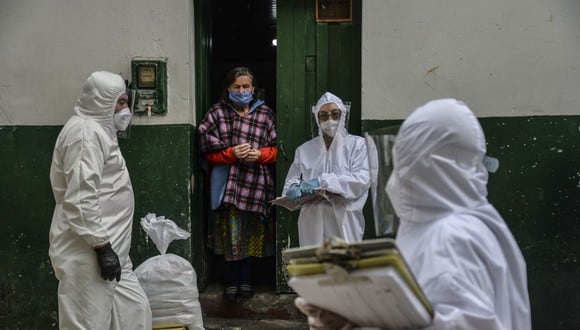 Los trabajadores de la Alcaldía de Bogotá usan trajes protectores para evitar infectarse con COVID-19, mientras realizan un censo en el vecindario de Egipto en Bogotá para saber cuántas familias deben recibir alimentos (Foto: Diana Sánchez / AFP)