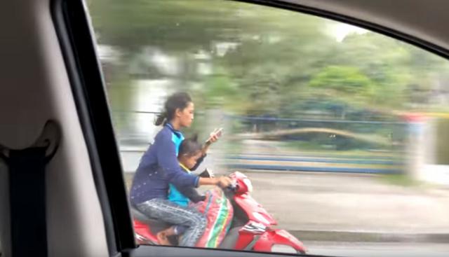 La mujer utiliza su celular de forma temeraria. (Facebook: @viralhog)