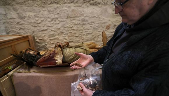 Un sacerdote muestra un trozo de una estatua de madera de Jesús que fue derribada y dañada en la Iglesia de la Condena, donde los cristianos creen que Jesús fue azotado y sentenciado a muerte, en la Ciudad Vieja de Jerusalén el 2 de febrero de 2023. (Foto: AHMAD GHARABLI / AFP)