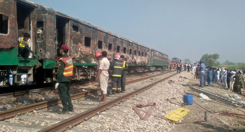 Las personas y los trabajadores de rescate se reúnen cerca del sitio después de que un incendio estalló en un tren de pasajeros y destruyó tres vagones cerca de la ciudad de Rahim Yar Khan. (Reuters)
