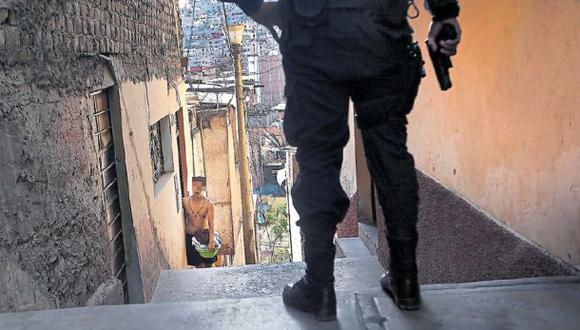 La polic&iacute;a, con sus armas rastrilladas, busca a tres delincuentes entre los callejones del cerro El Pino. Los hampones tambi&eacute;n est&aacute;n armados, pero saben donde esconderse. (Foto: Rolly Reyna / El Comercio)