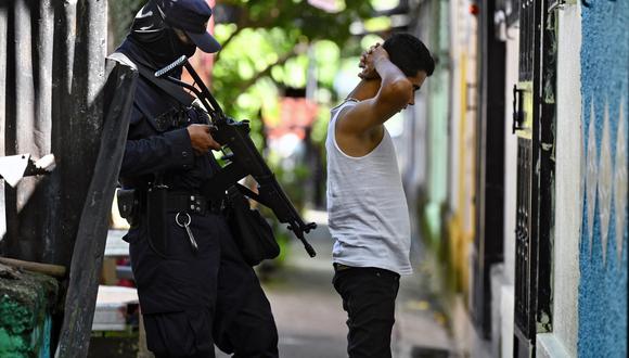 Un oficial de policía interroga a un joven durante una operación de seguridad contra la violencia de las pandillas en Soyapango, al este de la capital San Salvador, el 16 de agosto de 2022. (Foto por Sthanly ESTRADA / AFP)