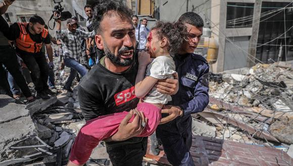 Un palestino evacua a su hija herida de entre los escombros de una casa destruida después de un ataque aéreo de Israel en la ciudad de Gaza, el 16 de mayo de 2021. (EFE / EPA / HAITHAM IMAD).