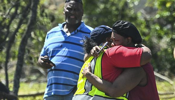 Un miembro de la familia (derecha) de Andrea Larry abraza a un bombero cuando su casa se incendia en Rolling Fork, Mississippi, luego de que un tornado azotara el área.