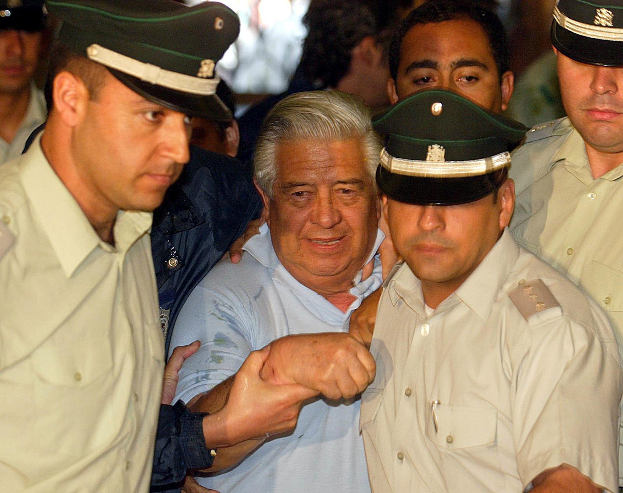 Police officers guard Gen.(R) Manuel Contreras upon his arrival to the court in Santiago, 28 January 2005. Five leaders of former Chilean dictator Augusto Pinochet's feared secret police force were taken into custody to serve terms of five to 12 years in the abduction of a young leftist. AFP PHOTO MARTIN BERNETTIOPSE 2005ENE30 CHILE DERECHOS HUMANOS DETENCION DE MANUEL CONTRERAS FUNCIONARIO DURANTE LA DICTADURA DE AUGUSTO PINOCHET 2005ENE30 AFD